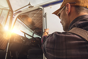 professional truck driver getting into a truck WLTNVW7